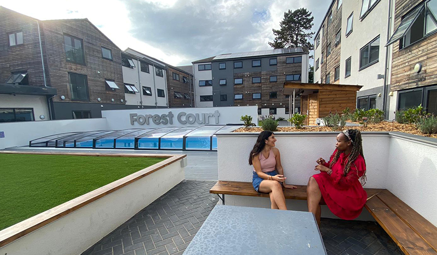 Students enjoying the garden near the heated pool in Loughborough's student accommodation